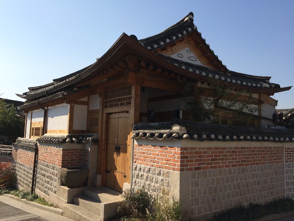 A traditional hanok house with a tiled roof and wooden gate in Bukchon Hanok Village, Seoul