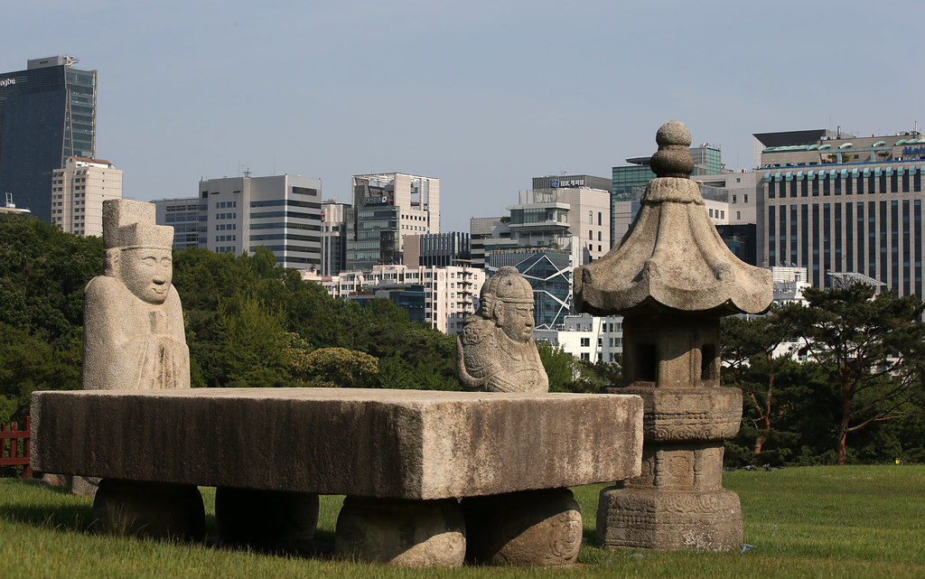 Stone guardian statues and lantern at Seonjeongneung royal tomb with Gangnam skyline