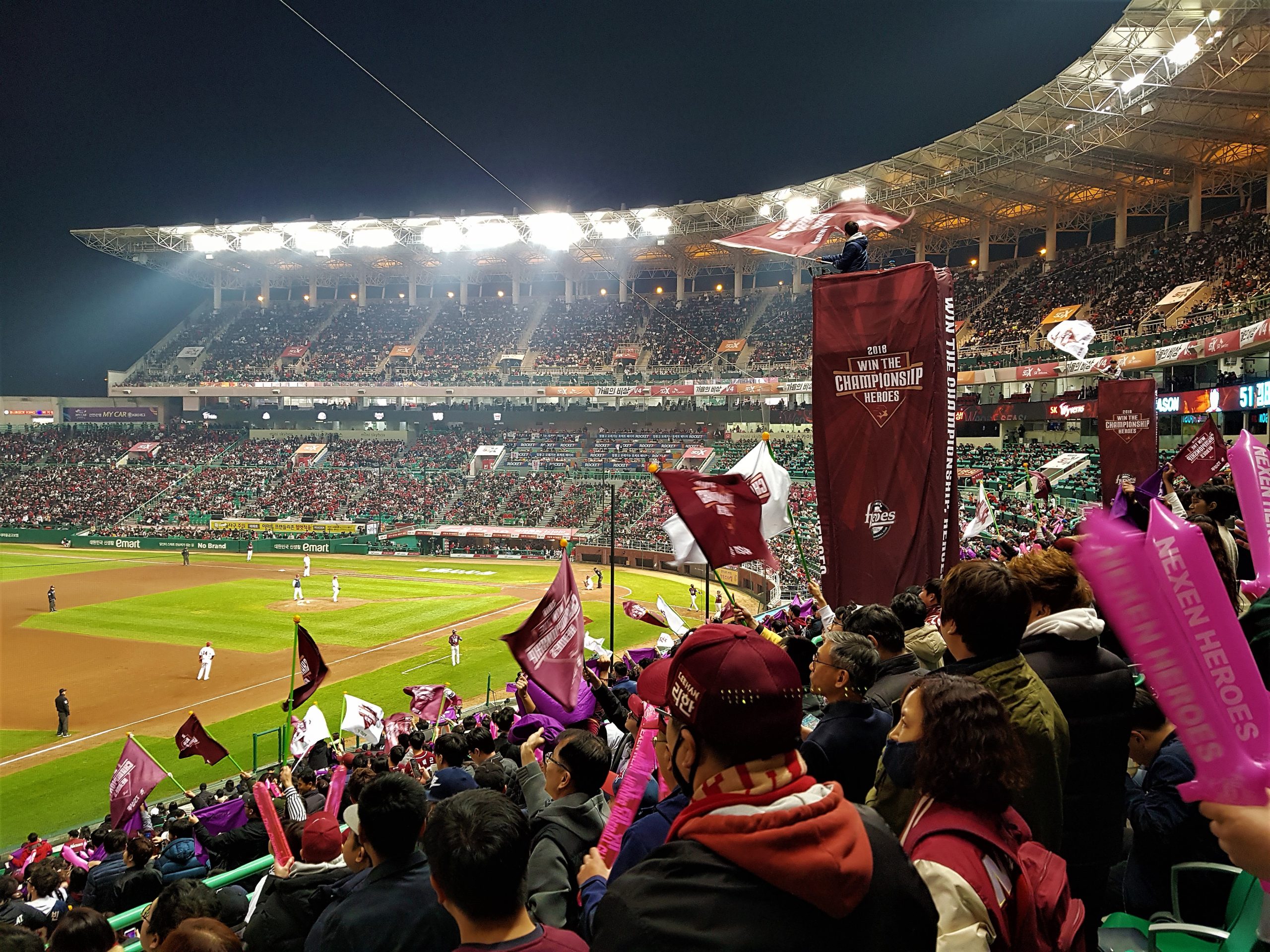 Fans waving flags during a night game at Gocheok Sky Dome