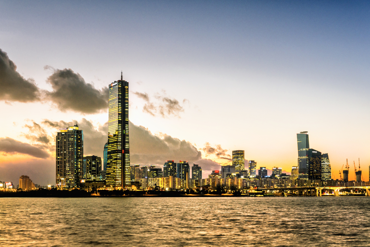 63 Square tower glowing over the Han River at dusk