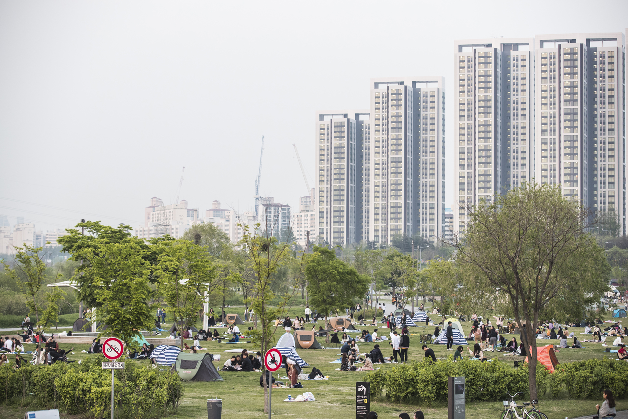 Banpo Hangang Park riverside lawns with picnickers and Seoul apartment towers behind
