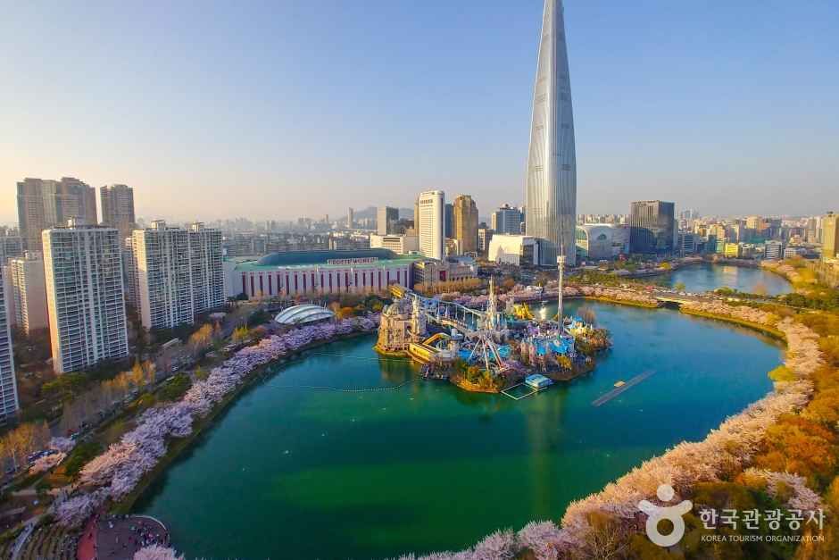 Lotte World Tower above Seokchon Lake with spring cherry blossoms