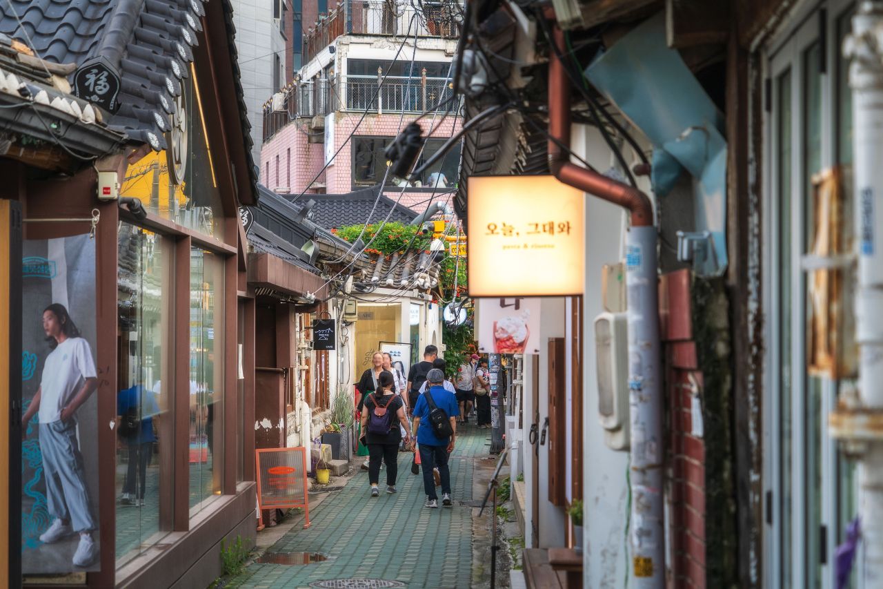 Crowded narrow alley with Korean signage in Ikseon-dong Hanok Village, Seoul
