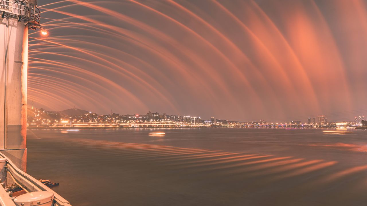 Banpo Bridge rainbow fountain spraying golden water over the Han River at dusk near Banpo Hangang Park