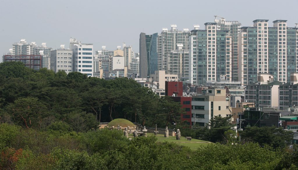 Seonjeongneung royal tomb grassy mound with stone statues below Gangnam apartment towers