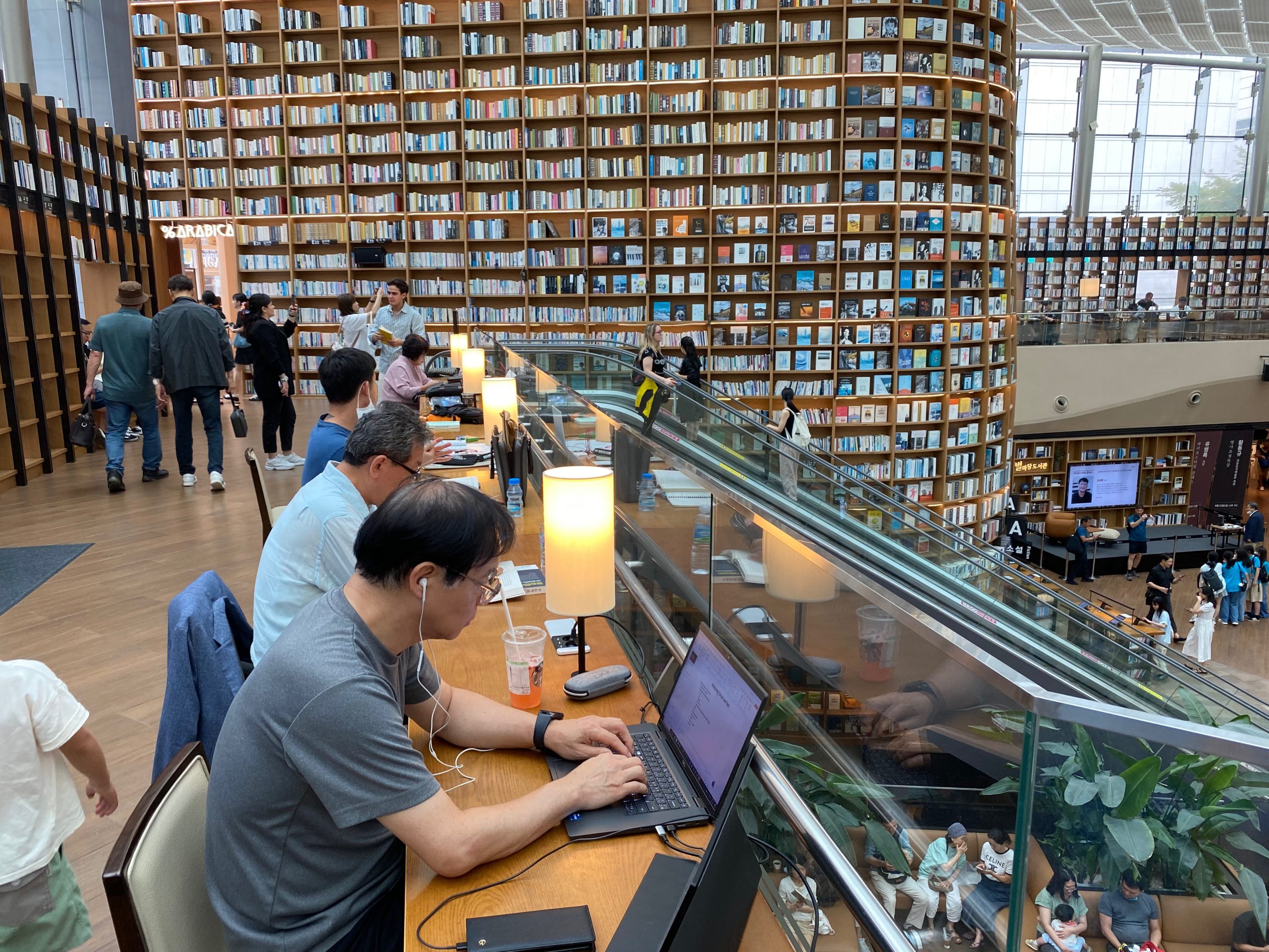 Visitors reading at communal tables in Starfield Library, COEX