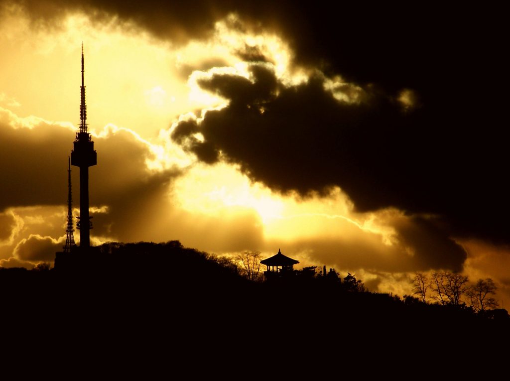 N Seoul Tower silhouetted against a golden sunset sky on Namsan, Seoul