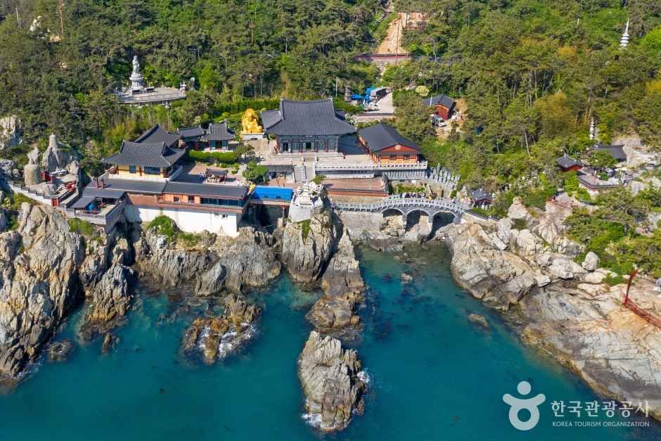 Haedong Yonggungsa from above, its halls and golden statues set on sea cliffs in Gijang-gun, Busan