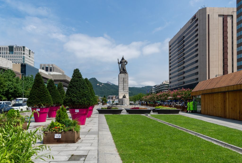Gwanghwamun Square in Seoul with the Admiral Yi Sun-sin statue, lawns and mountains