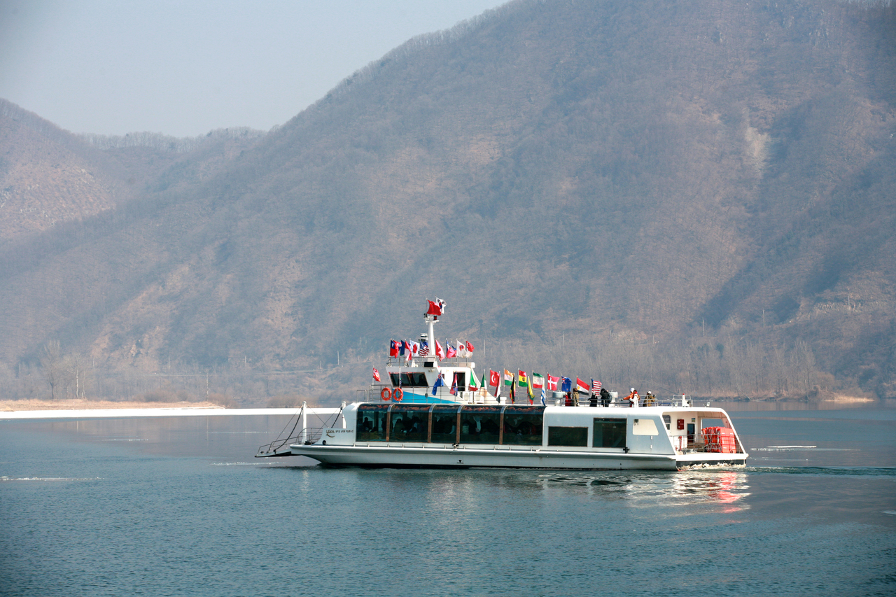 Ferry crossing the Bukhan River to Nami Island with flags along its deck