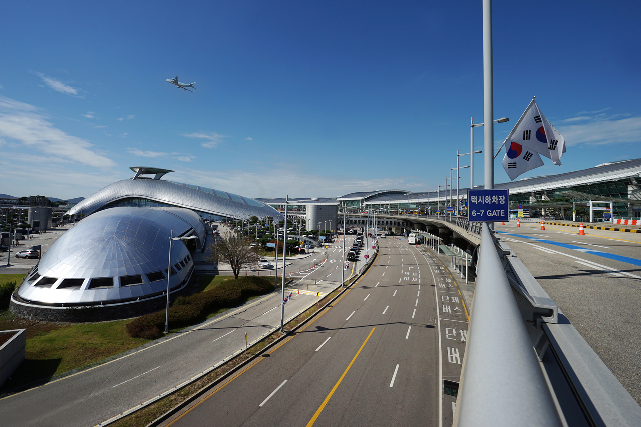 Incheon International Airport terminal frontage with taxi drop-off and bus lane signage