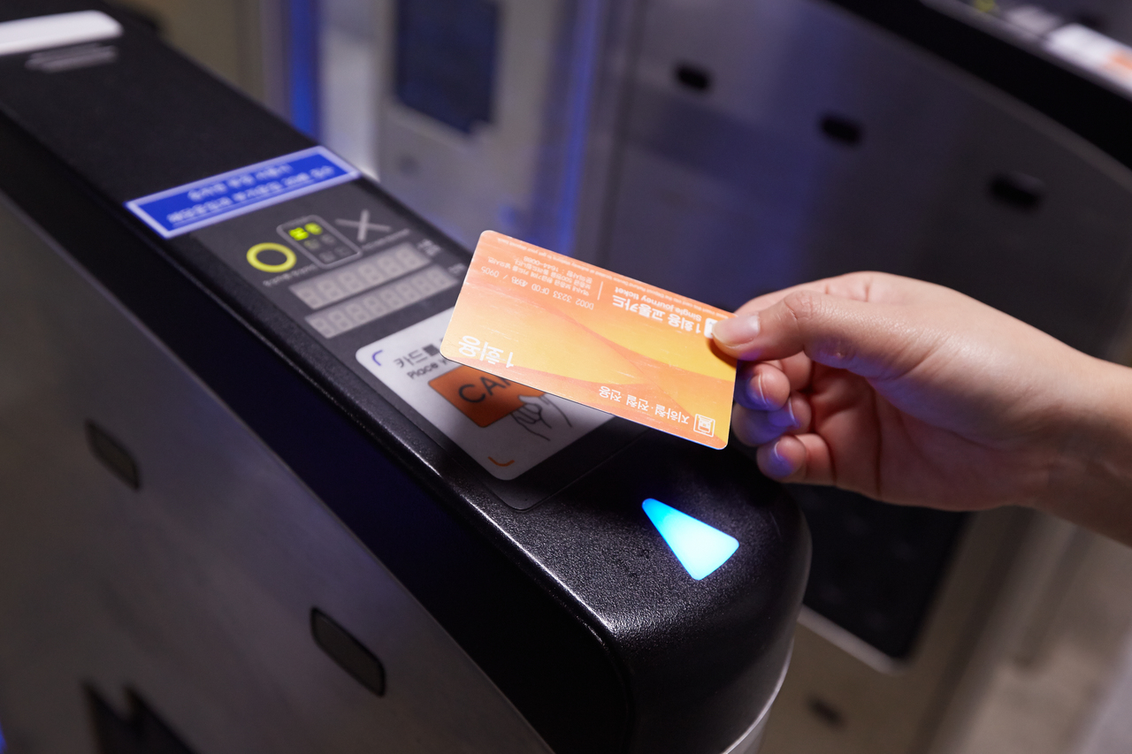 Close-up of a transit card being tapped on a Seoul subway fare gate reader