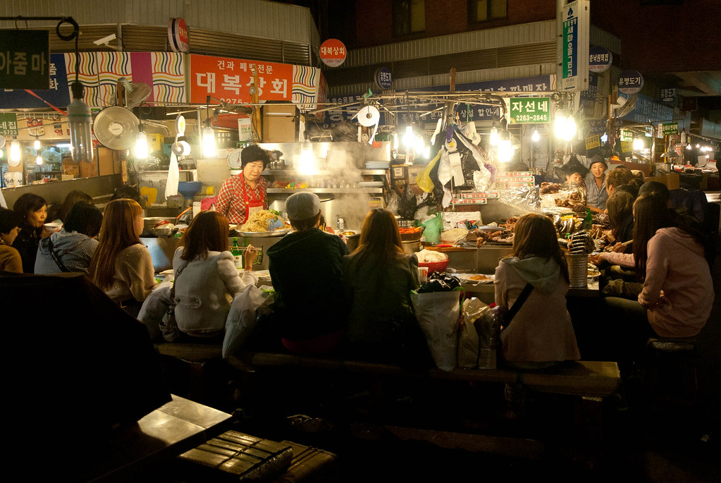 Diners at food stalls inside Gwangjang Market, Seoul