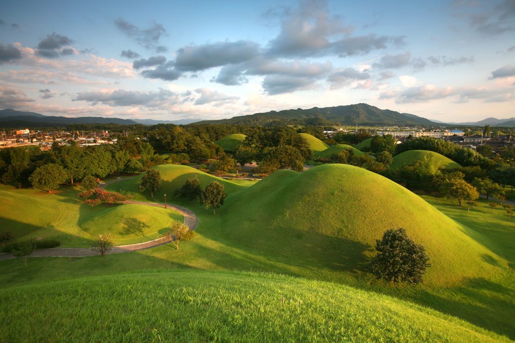 Grass-covered Silla royal tombs at Daereungwon in Gyeongju at golden hour