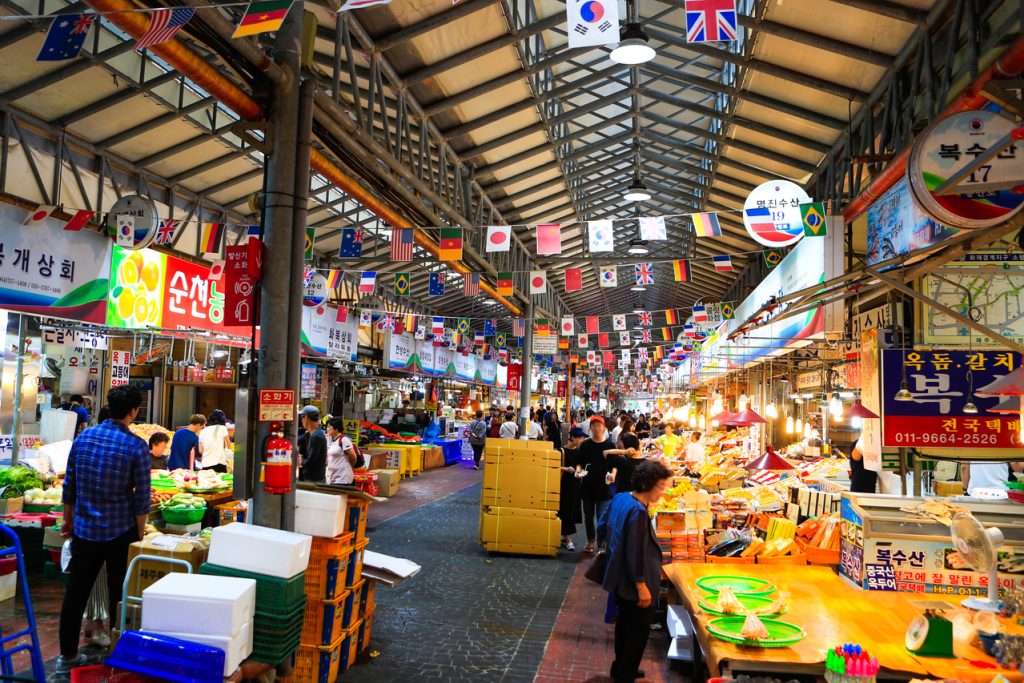 Covered arcade of Dongmun Market in Jeju City lined with stalls and signs