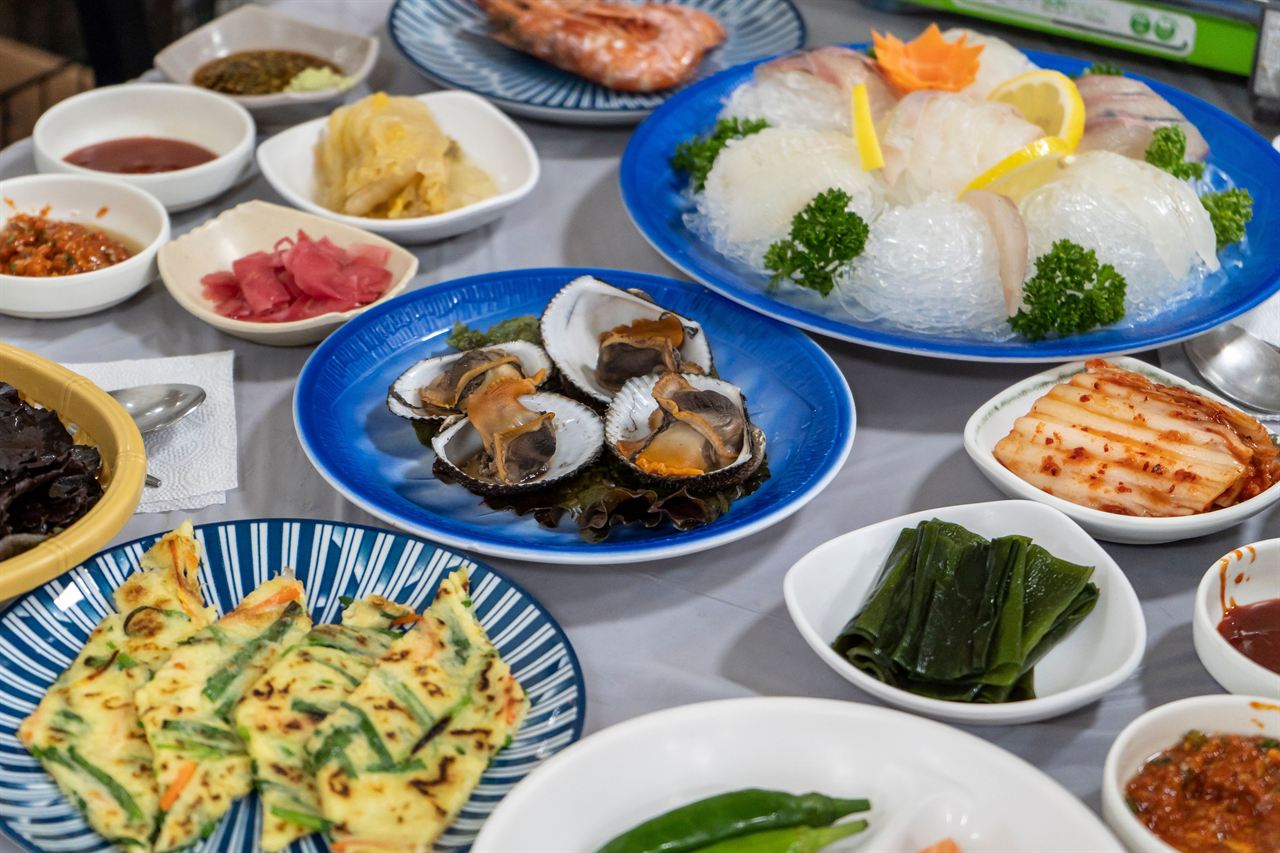 Sliced raw fish platter with side dishes at Jagalchi Market